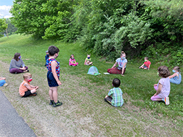 students sitting in a circle on grass